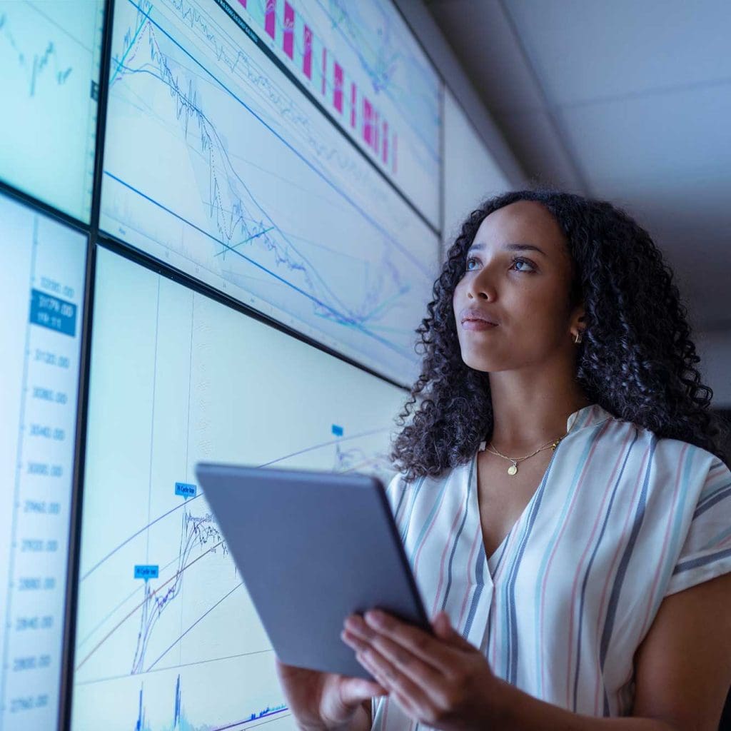 Businesswoman holding a tablet device in business attire.