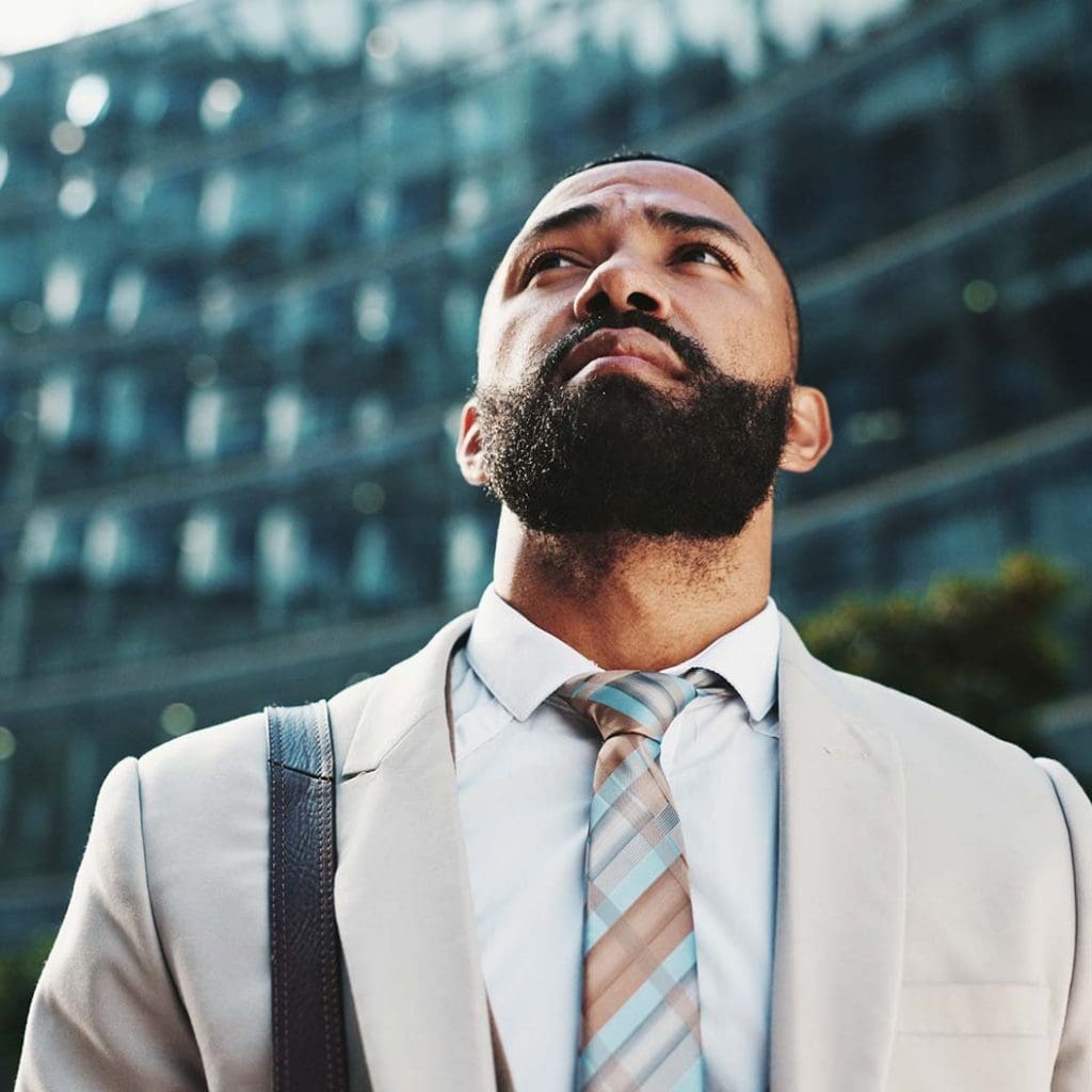 Employee commuting through city streets, man walking and thinking in urban environment.